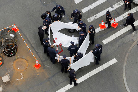 New York Police Department officers stand around a covered body after a shooting in midtown Manhattan in New York, U.S., May 18, 2016. REUTERS/Lucas Jackson