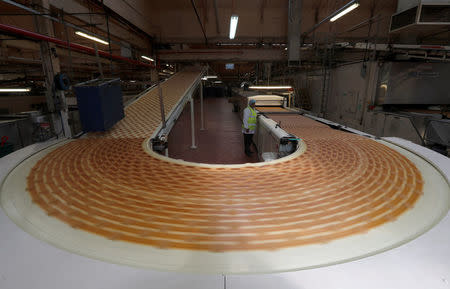 A worker inspects biscuits on the production line of Pladis' McVities factory in London Britain, September 19, 2017. Picture taken September 19, 2017. REUTERS/Peter Nicholls.