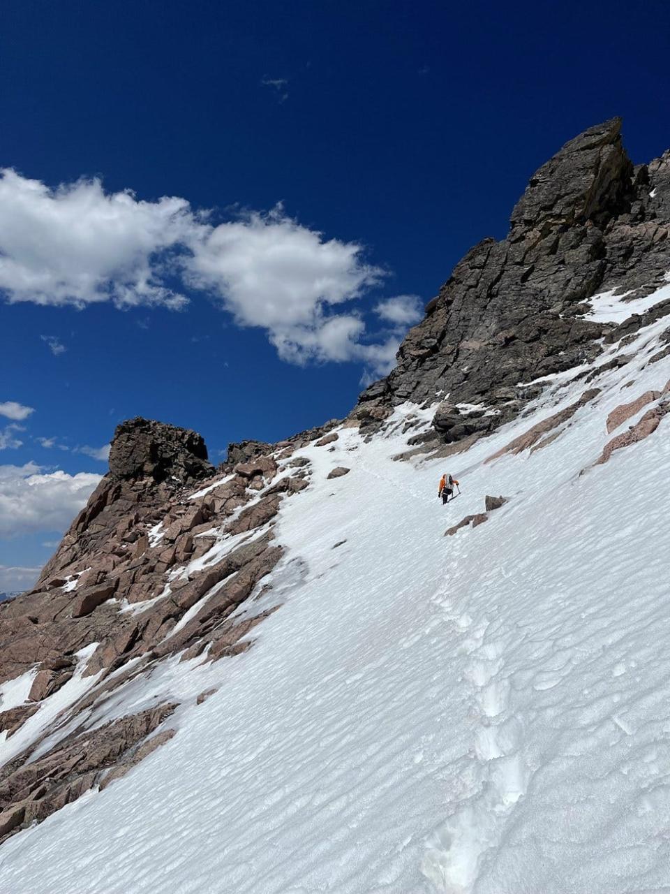 A Rocky Mountain National Park ranger is shown traversing deep snow on the Ledges section of Longs Peak on June 25, 2023.