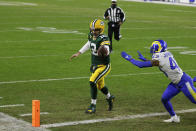 Green Bay Packers quarterback Aaron Rodgers scores on a one-yard touchdown run past Los Angeles Rams' John Johnson during the first half of an NFL divisional playoff football game, Saturday, Jan. 16, 2021, in Green Bay, Wis. (AP Photo/Matt Ludtke)