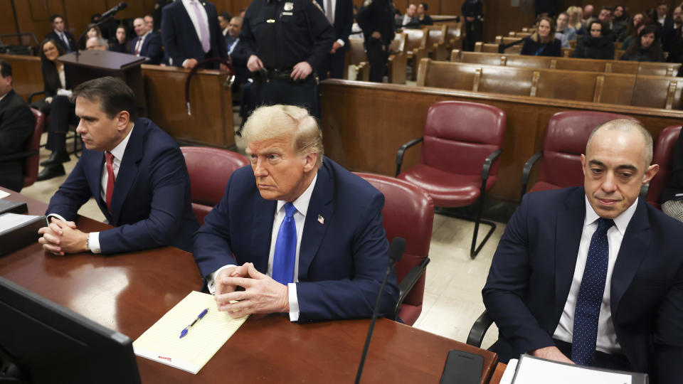 Former president Donald Trump, center, awaits the start of proceedings at Manhattan criminal court, Monday, April 22, 2024, in New York. Opening statements in Donald Trump's historic hush money trial are set to begin. Trump is accused of falsifying internal business records as part of an alleged scheme to bury stories he thought might hurt his presidential campaign in 2016. (AP Photo/Yuki Iwamura, Pool)