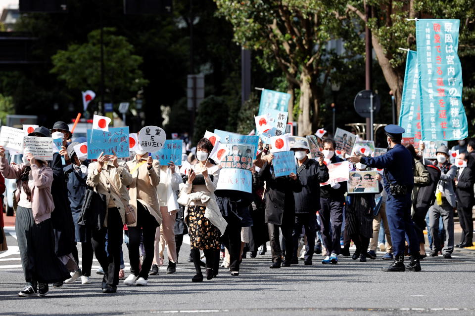 Protesters hold banners during a march against the marriage of Japan's Princess Mako and Kei Komuro in Tokyo on October 26, 2021. / Credit: KIM KYUNG-HOON / REUTERS