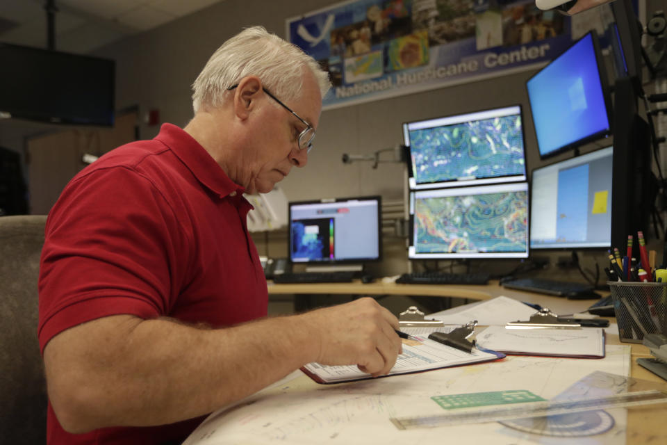 Senior hurricane specialist Stacy Stewart monitors the progress of Tropical Storm Dorian at the National Hurricane Center, Tuesday, Aug. 27, 2019, in Miami. (AP Photo/Lynne Sladky)