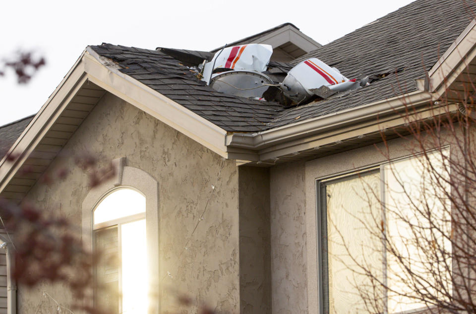 Debris from a small plane that crashed in Roy, Utah, is lodged in the roof of a home on Wednesday, Jan. 15, 2020. Authorities say the small plane crashed in a Utah neighborhood, killing the pilot as the aircraft narrowly avoided hitting any townhomes. Roy police Sgt. Matthew Gwynn said the 64-year-old pilot was making a short flight from Bountiful to Ogden in a twin-engine Cessna Wednesday but crashed in the city of Roy about 30 miles north of Salt Lake City. (Steve Griffin/The Deseret News via AP)