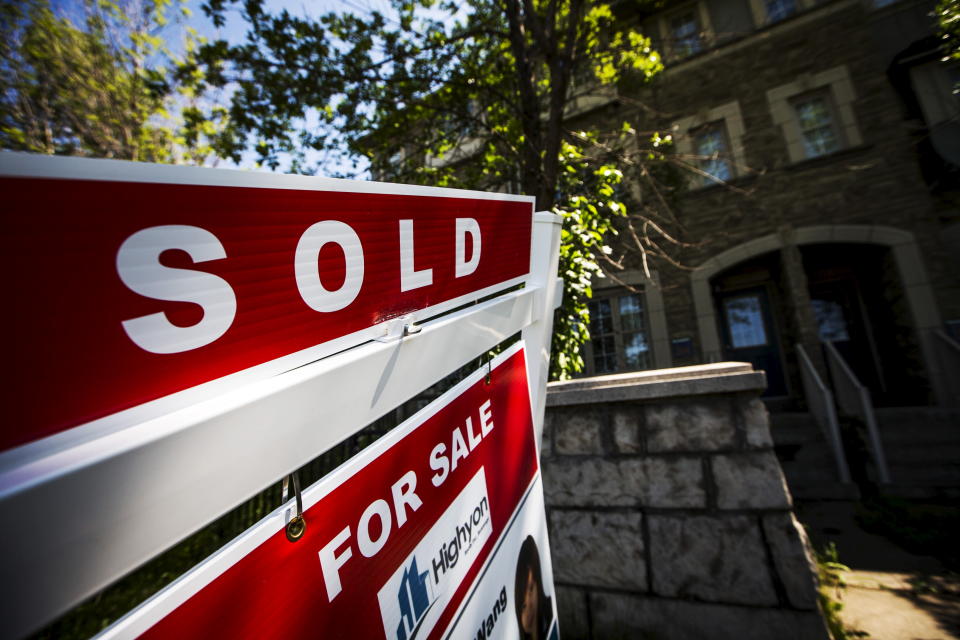 A "For Sale" sign stands in front of a home that has been sold in Toronto