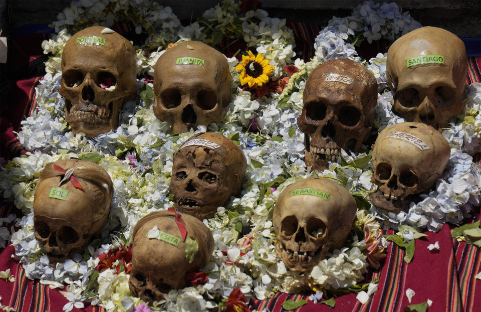 Cráneos humanos decorados y etiquetados con nombres se exhiben para ser bendecidos por un sacerdote durante la fiesta anual de las ñatitas, una tradición que marca el final de la festividad católica de Todos los Santos, en el Cementerio General de La Paz, Bolivia, el martes 8 de noviembre de 2022. (AP Foto/Juan Karita)