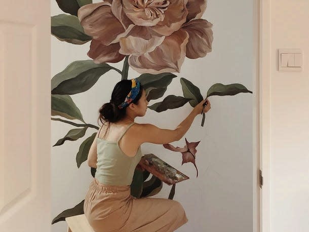 Progress photo of Toh painting her rose mural.