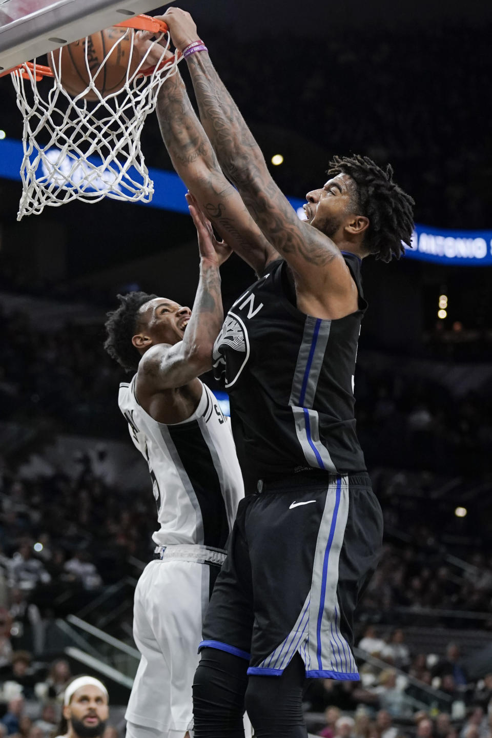 Golden State Warriors' Marquese Chriss, right, dunks against San Antonio Spurs' Dejounte Murray during the first half of an NBA basketball game, Tuesday, Dec. 31, 2019, in San Antonio. (AP Photo/Darren Abate)