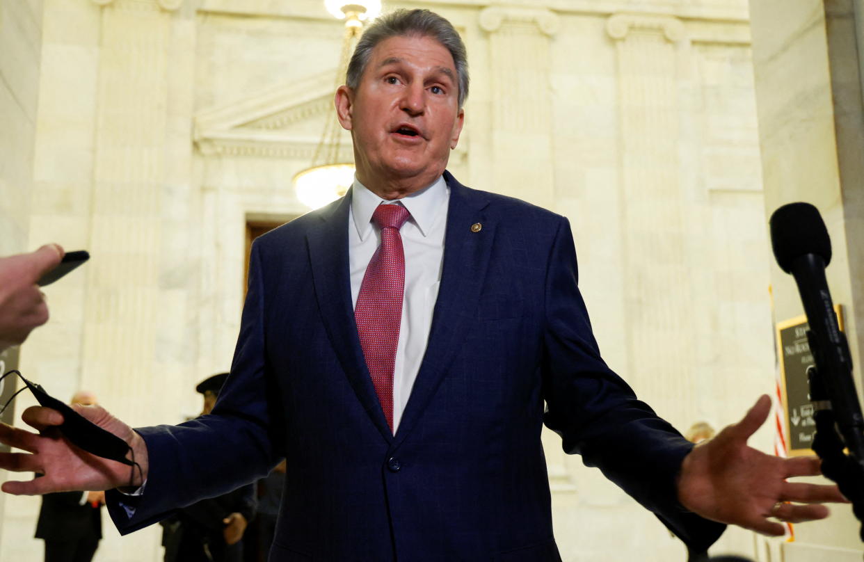 Sen. Joe Manchin gestures as he speaks with the media on Capitol Hill.