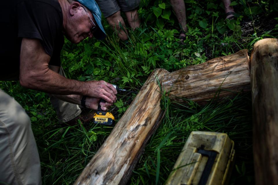Eric Chittenden screws together two pieces of the base of a loon nesting raft in Stowe, VT, July 15, 2019. 