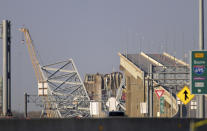 A crane is seen near the wreckage of the Francis Scott Key Bridge on Friday, March 29, 2024 in Baltimore. A cargo ship rammed into the major bridge in Baltimore early Tuesday, causing it to collapse in a matter of seconds. (AP Photo/Steve Ruark)