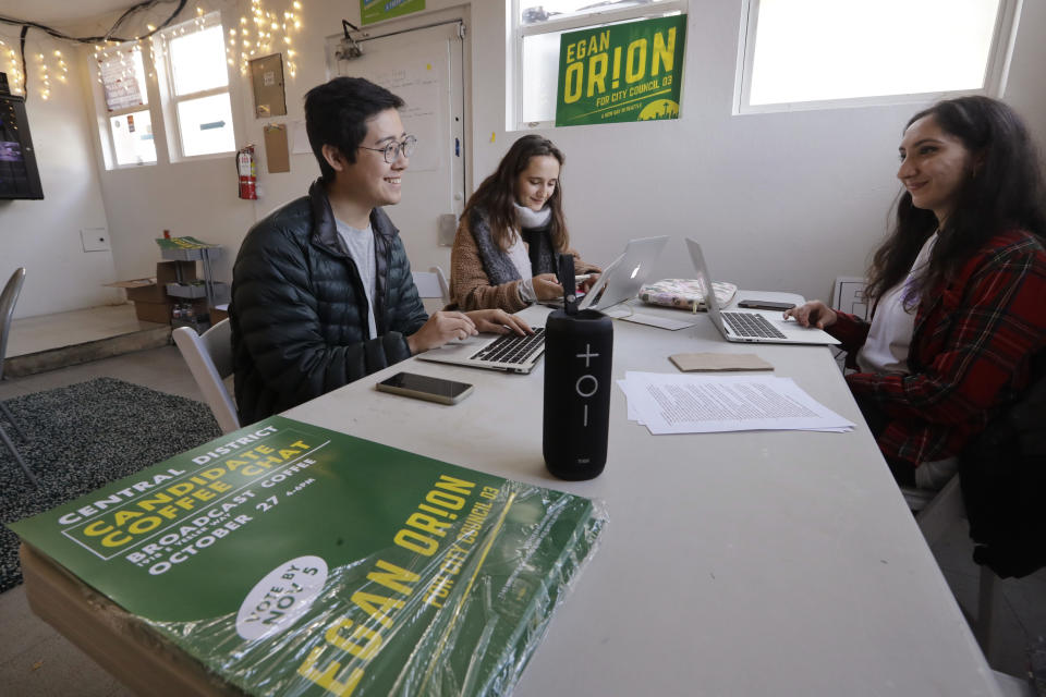In this Wednesday, Oct. 23, 2019 photo, Seattle City Council candidate Egan Orion's staff members Harrison Louie, left, Olga Laskin and Akansha Bhat work at the campaign's headquarters in Seattle. Seven of the nine Seattle City Council seats are up for grabs in next month's election, where retail giant Amazon has made unprecedented donations totaling $1.5 million to a political action committee that's supporting a slate of candidates perceived to be friendlier to business. Among the company's top targets is socialist council member Kshama Sawant, a fierce critic of Amazon, and Orion's opponent in the District 3 race. (AP Photo/Elaine Thompson)