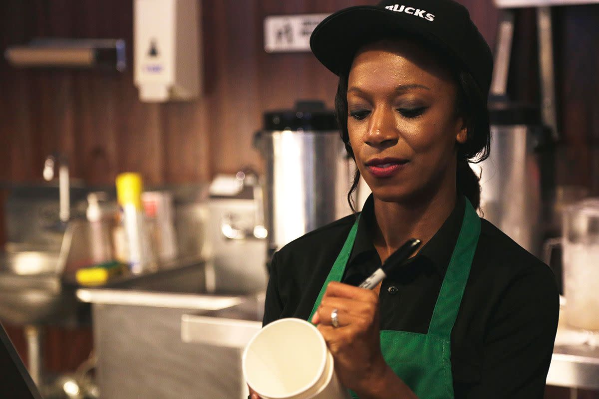 Starbucks barista writing name on a coffee cup