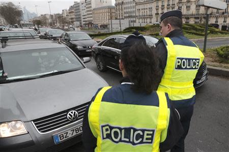 Police officers control cars with even-numbered licence plates which are not allowed to drive today, at Porte Maillot in Paris March 17, 2014. REUTERS/Philippe Wojazer