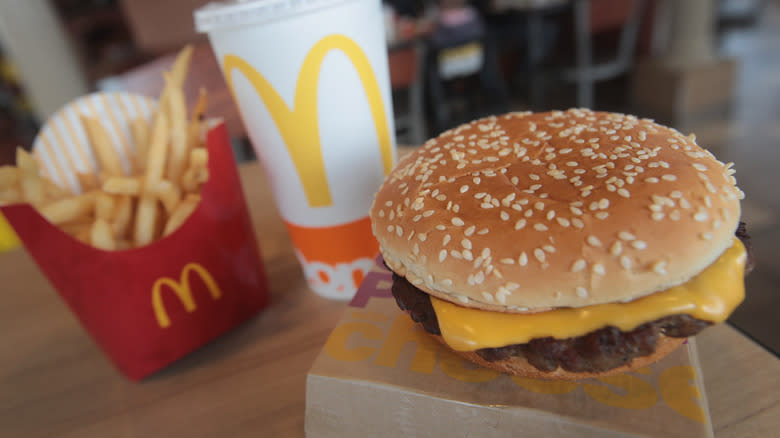 McDonald's cheeseburger, fries, and soda on table