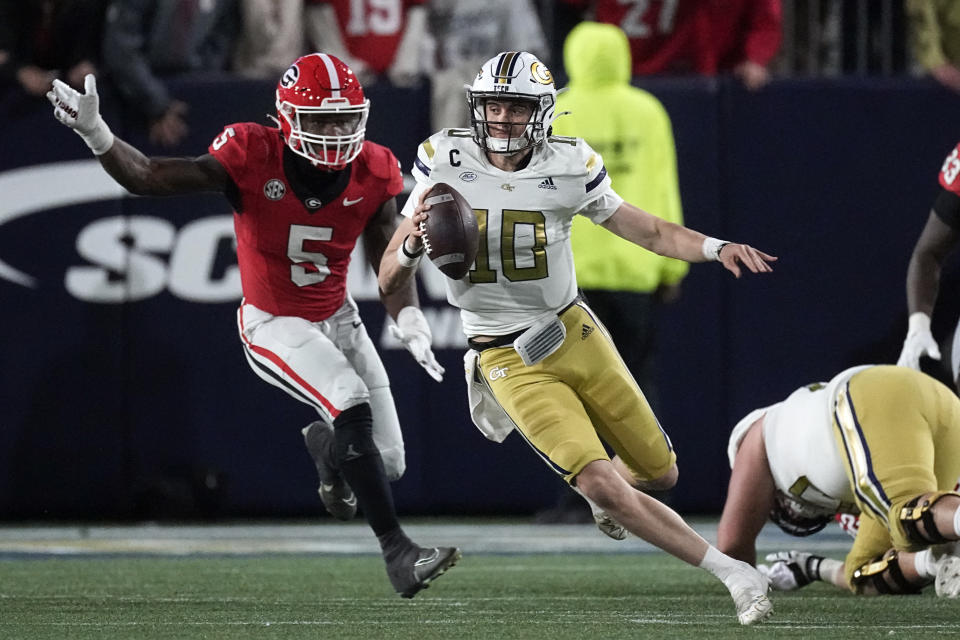 Georgia Tech quarterback Haynes King (10) is chased by Georgia linebacker Raylen Wilson (5) during the second half of an NCAA college football game, Saturday, Nov. 25, 2023, in Atlanta. (AP Photo/John Bazemore)