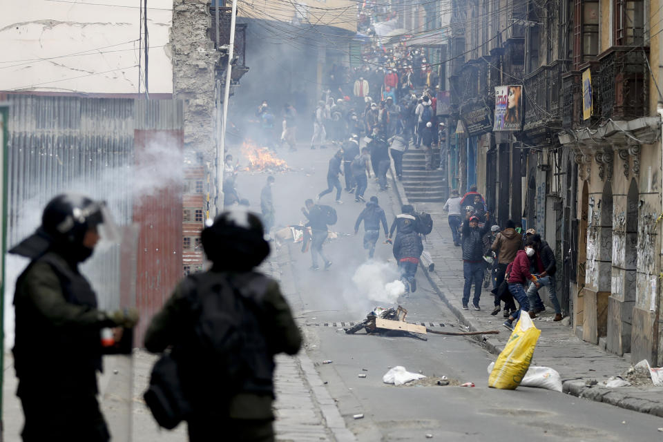 Backers of former President Evo Morales clash with police in La Paz, Bolivia, Wednesday, Nov. 13, 2019. Bolivia's new interim President Jeanine Anez faces the challenge of stabilizing the nation and organizing national elections within three months at a time of political disputes that pushed Morales to fly off to self-exile in Mexico after 14 years in power. (AP Photo/Natacha Pisarenko)