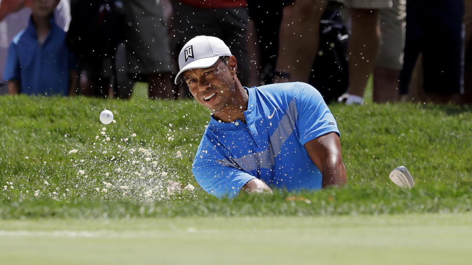 FILE - In this Thursday, Aug. 15, 2019 file photo, Tiger Woods hits from a sand trap on the fourth hole during the first round of the BMW Championship golf tournament at Medinah Country Club in Medinah, Ill. Woods is in the Bahamas this week as a player and a host, and in Australia next week as a player and Presidents Cup captain. (AP Photo/Nam Y. Huh, File)