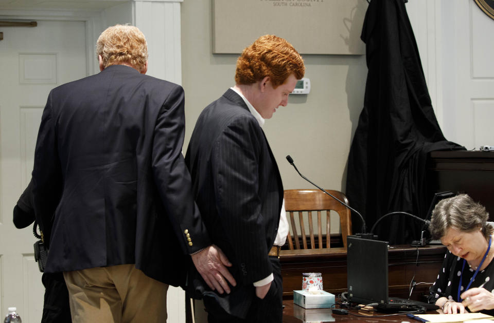 Alex Murdaugh, left, gives his son Buster Murdaugh a pat during a break in testimony during trial at the Colleton County Courthouse in Walterboro, S.C., on Tuesday, Feb. 21, 2023. The 54-year-old attorney is standing trial on two counts of murder in the shootings of his wife and son at their Colleton County, S.C., home and hunting lodge on June 7, 2021. (Grace Beahm Alford/The Post And Courier via AP, Pool)