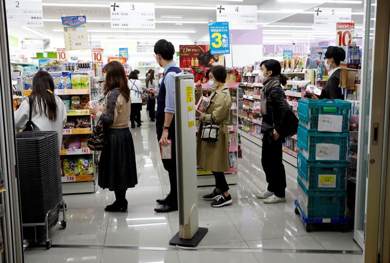 People wearing protective face masks following an outbreak of the coronavirus disease queue to buy masks at a drugstore in Tokyo, Japan