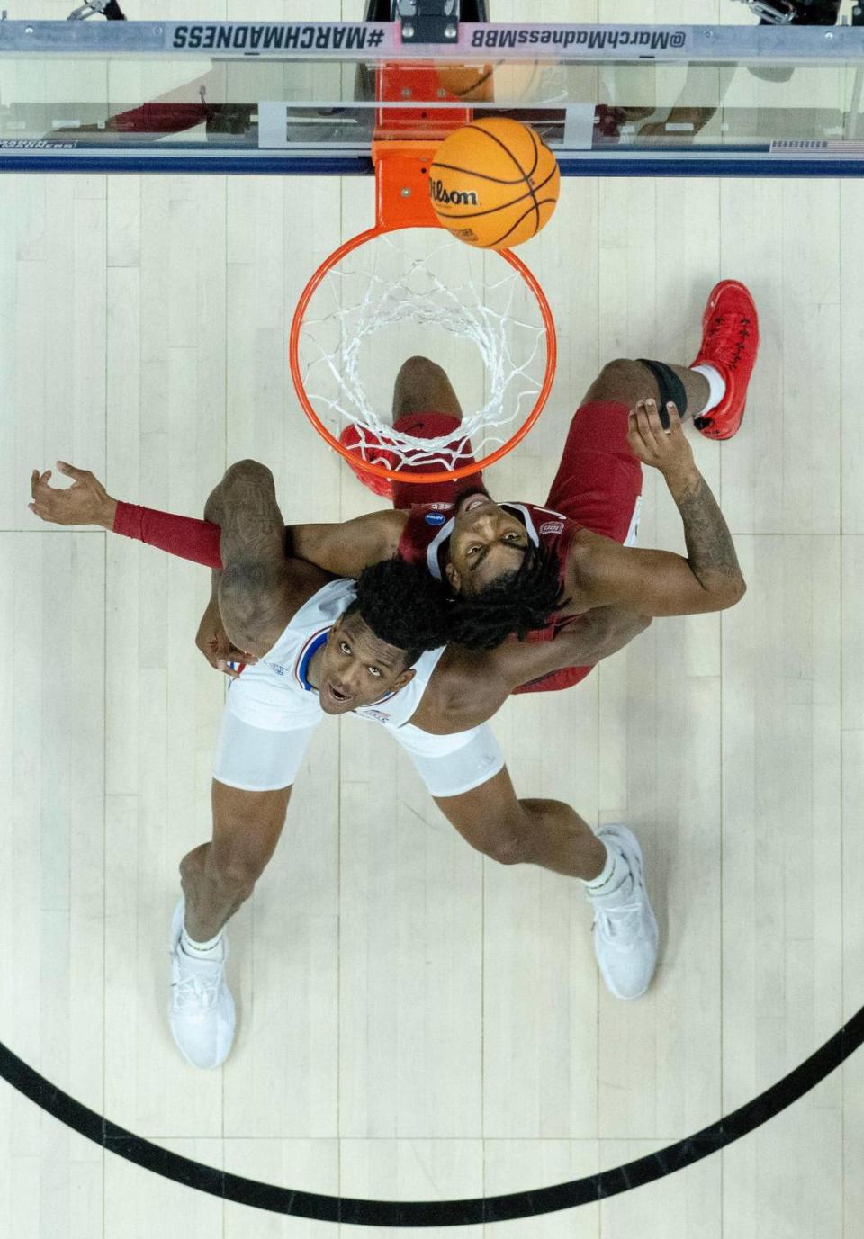 Kansas forward K.J. Adams Jr. (24) battles for a rebound with Arkansas forward Kamani Johnson (20) during a second-round college basketball game in the NCAA Tournament Saturday, March 18, 2023, in Des Moines, Iowa.