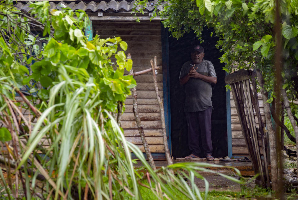 A man stands on the doorframe of his home after Hurricane Ian's storm surge flooded the area in Boca de Cajio, Artemisa, Cuba, Tuesday, September 27, 2022. Ian made landfall at 4:30 a.m. EDT Tuesday in Cuba's Pinar del Rio province, where officials set up shelters, evacuated people, rushed in emergency personnel and took steps to protect crops in the nation's main tobacco-growing region. (AP Photo/Ismael Francisco)