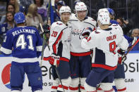 Washington Capitals' Brett Leason (49), is congratulated on his first NHL goal by teammates Lars Eller (20), of Denmark and Dmitry Orlov (9), of Russia, as Tampa Bay Lightning's Pierre-Edouard Bellemare reacts during the first period of an NHL hockey game Monday, Nov. 1, 2021, in Tampa, Fla. (AP Photo/Mike Carlson)