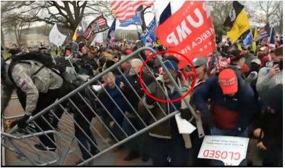 Federal authorities say Cleophus Dulaney, 63, of Columbus, is seen here (circled) in this photo removing a bike rack barricade to allow a mob of rioters to storm the U.S. Capitol during the Jan. 6, 2021, insurrection.