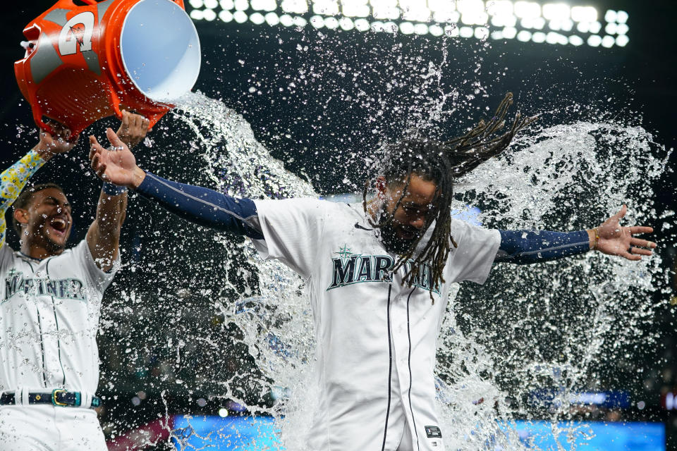 Seattle Mariners' Julio Rodríguez, left, laughs as he douses J.P. Crawford, who drove in the tying and winning runs with a double against the Texas Rangers during the ninth inning of a baseball game Thursday, Sept. 28, 2023, in Seattle. (AP Photo/Lindsey Wasson)