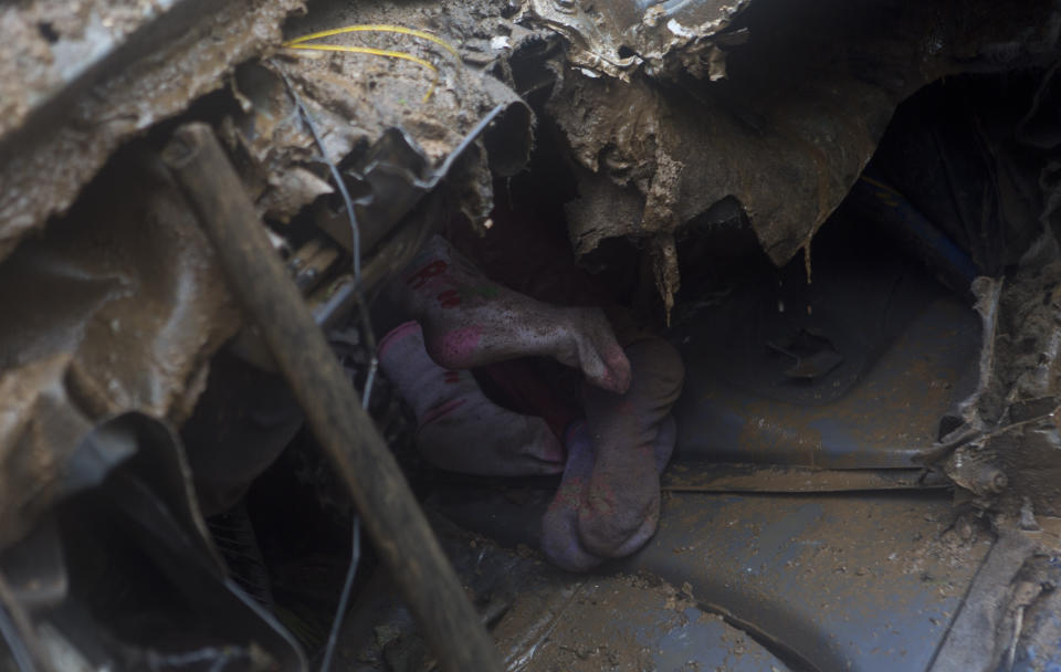 The feet of children who died are seen inside a car after a mudslide on the outskirts of El Choro, Bolivia, Saturday, Feb. 2, 2019. According to police, at least five people died and others were injured after vehicles were dragged Saturday by a mudslide on a mountainous road in the north of La Paz. (AP Photo/Juan Karita)