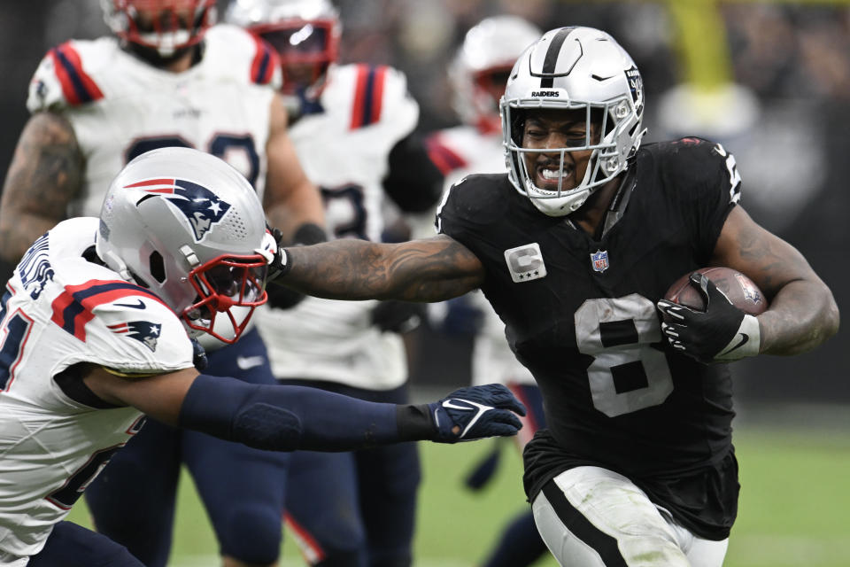 Oct 15, 2023; Paradise, Nevada, USA; Las Vegas Raiders running back Josh Jacobs (8) tries to avoid a tackle from New England Patriots safety Adrian Phillips (21) at Allegiant Stadium. Mandatory Credit: Candice Ward-USA TODAY Sports