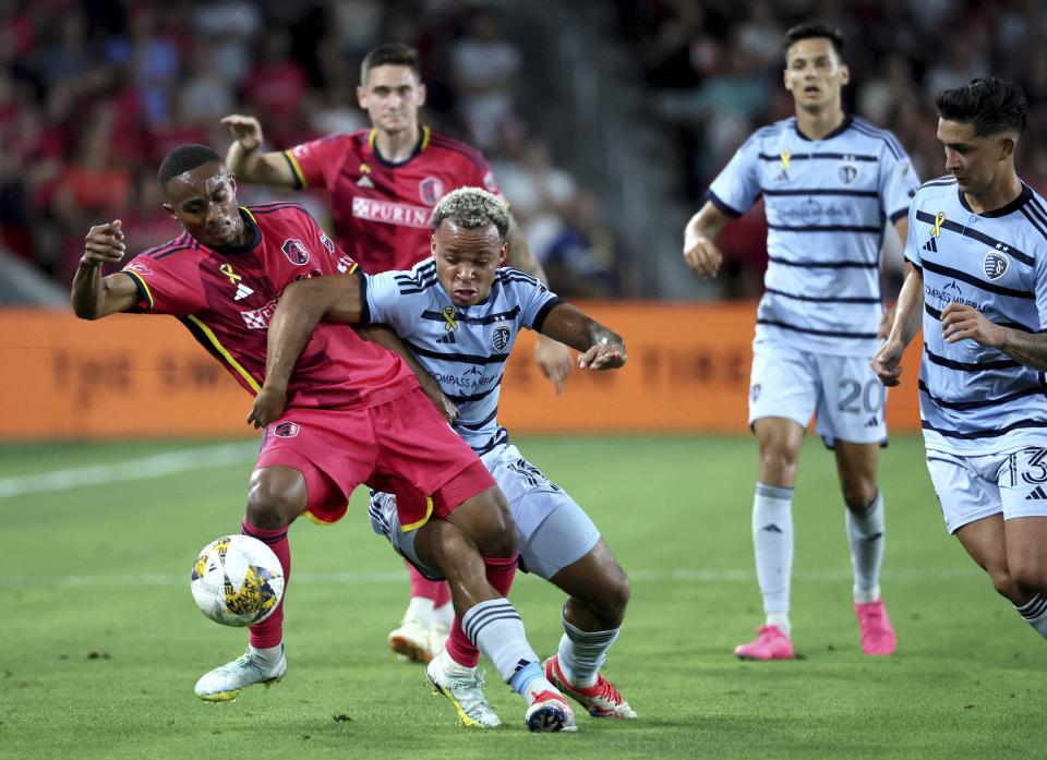 St. Louis City SC midfielder Njabulo Blom, left, is fouled by Sporting Kansas City defender Logan Ndenbe during the first half of an MLS soccer match in St. Louis on Saturday, Sept. 30, 2023. (David Carson/St. Louis Post-Dispatch via AP)