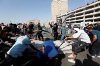 Iraqi demonstrators pull concrete walls at Sinak Bridge during the ongoing anti-government protests, in Baghdad