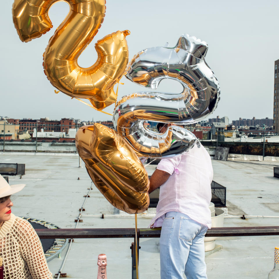 Sid Singh arregla globos con forma de símbolos de dólar durante el 