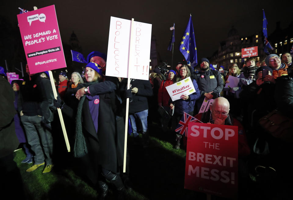 Anti-Brexit demonstrators react after the results of the vote on British Prime Minister Theresa May's Brexit deal were announced in Parliament square in London, Tuesday, Jan. 15, 2019. British lawmakers have rejected Prime Minister Theresa May's Brexit deal by a huge margin, plunging U.K. politics into crisis 10 weeks before the country is due to leave the European Union. The House of Commons voted 432 -202 on Tuesday against the deal struck between Britain's government and the EU in November. (AP Photo/Frank Augstein)