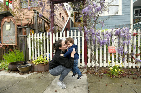 Joy Ashe holds her son Zion Ashe, 1, outside their home in Emeryville, California, United States March 20, 2017. Ashe, who has spoken before the city's planning commission and city council, is concerned about lead and other pollutants from a property renovation across the street from her home. To match Special Report USA-LEAD/CALIFORNIA REUTERS/Noah Berger