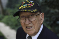 Harold Angle, 96, from the 112th infantry regiment 28th division, poses during an interview with the Associated Press Friday, Aug.23, 2019 in Paris. Harold Angle landed in Normandy in 1944, and moved quickly into eastern France, where his division fought through a brutal winter, losing comrades and morale. He saved a piece of a bullet that hit his helmet, with a wartime photo of himself and a letter he wrote home to his mother, describing his scrape with death.(AP Photo/Daniel Cole)