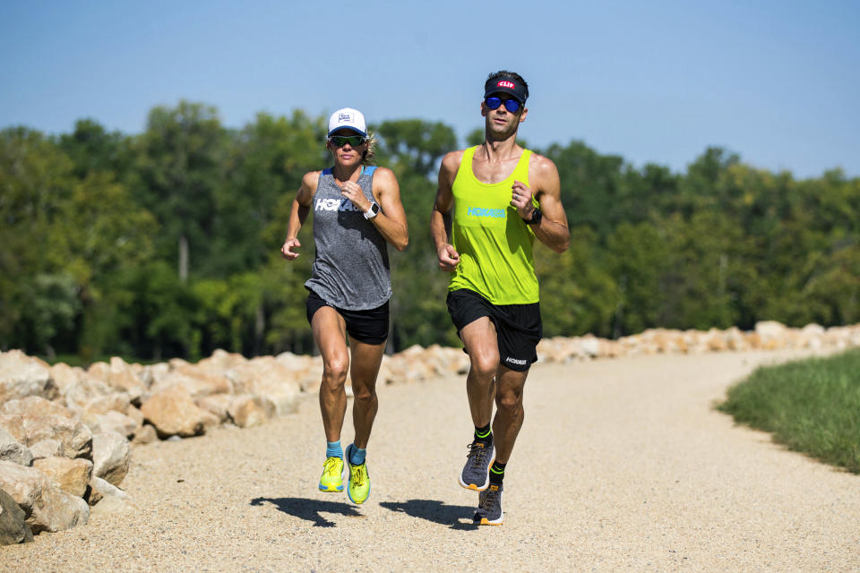 In this undated photo, three-time Ironman world champion Mirinda Carfrae, left, and her husband, elite triathlete Tim O'Donnell put in a training run along the Kansas River in Lawrence, Kan. The couple are preparing for next month's Ironman world championships in Kona, Hawaii, while also raising a 1-year-old daughter, Isabelle. (Talbot Cox via AP)