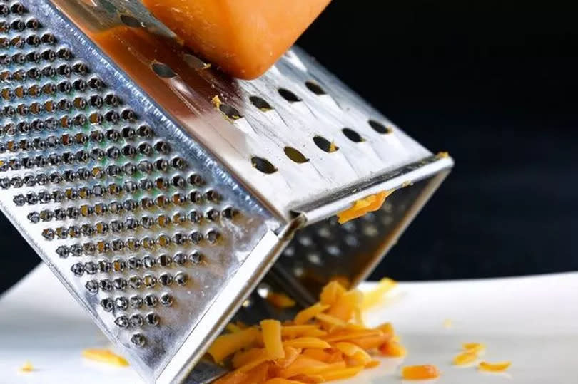 someone grating cheese