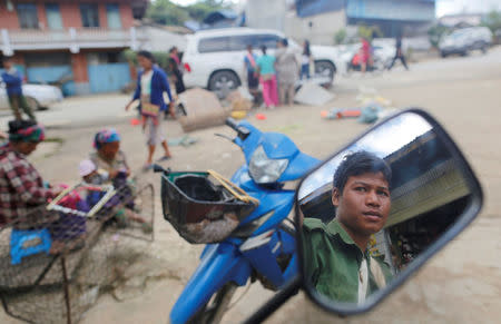A United Wa State Army (UWSA) soldier reflected on mirror as he sits on a motorbike in a market at Mongmao, Wa territory in northeast Myanmar October 1, 2016. REUTERS/Soe Zeya Tun