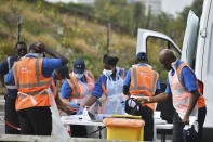 Workers prepare ahead of opening at a Coronavirus testing centre in Southwark, south London, Wednesday, Sept. 16, 2020. The British government plans to ration coronavirus testing, giving priority to health workers and care home staff after widespread reports that people throughout the country were unable to schedule tests. Prime Minister Boris Johnson on Wednesday will face questions about his handling of the COVID-19 pandemic in the House of Commons and before a key committee amid the outcry over the shortage of testing. (Dominic Lipinski/PA via AP)