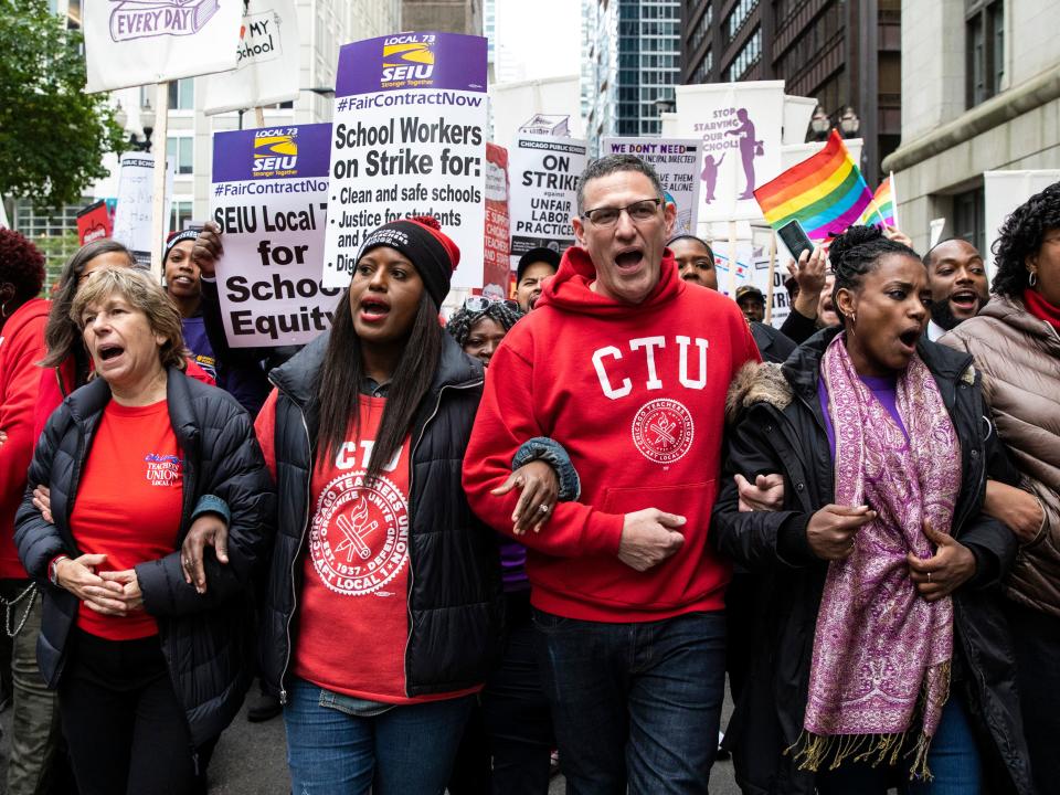 Chicago Teachers Union Vice President Stacy Davis Gates, center, left, and CTU President Jesse Sharkey, center, right, lead thousands of striking union members on a march through the Loop, Thursday, Oct. 17, 2019, in Chicago. Striking teachers went on strike after their union and city officials failed to reach a contract deal in the nation's third-largest school district. (Ashlee Rezin Garcia/Chicago Sun-Times via AP)