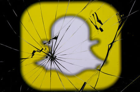 Snapchat logo is seen through broken glass in this illustration picture, May 11, 2017. REUTERS/Dado Ruvic/Illustration