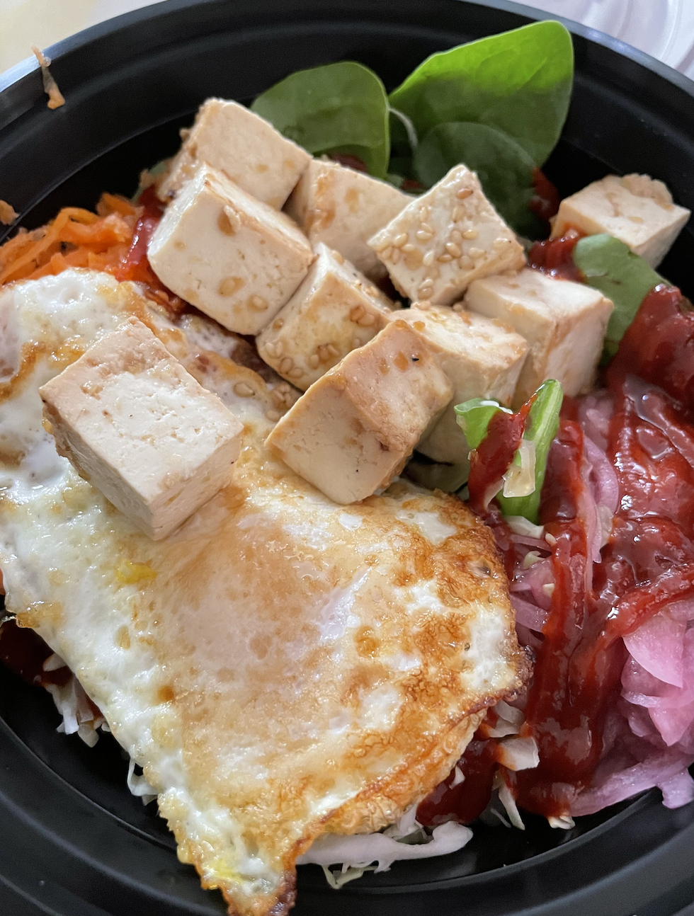 For a veggie-packed meal that keeps you full, the tofu bibimbap from Topped Waikiki is a great choice for under $15.