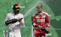 Formula One - F1 - Mexican F1 Grand Prix - Mexico City, Mexico - 30/10/16 - Race winning Mercedes' driver Lewis Hamilton of Britain (L) sprays champagne with third placed finishing Ferrari driver Sebastian Vettel of Germany. REUTERS/Henry Romero
