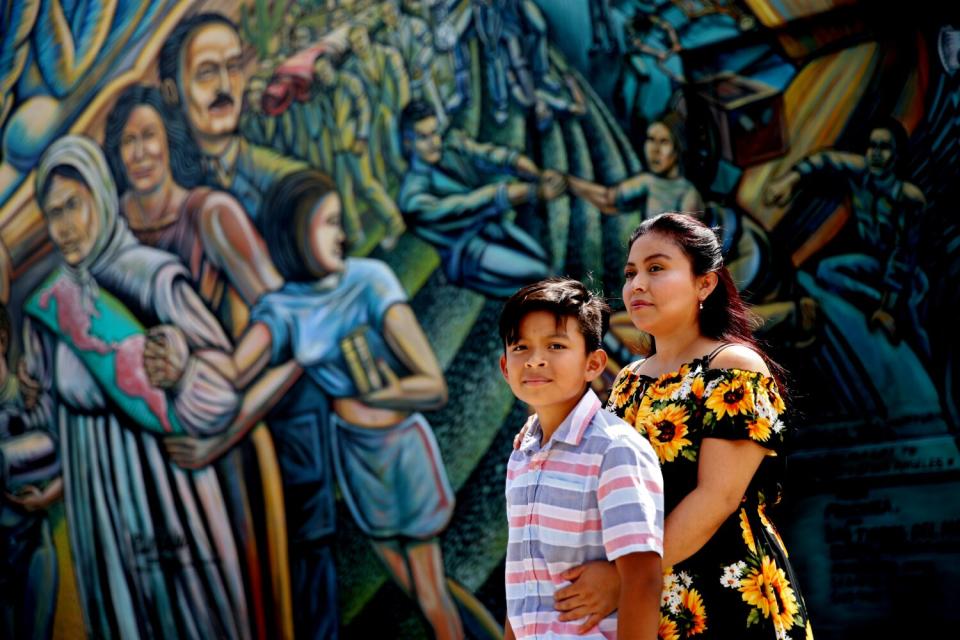 Lucrecia Puac Hernandez and her son stand in front of a mural in L.A.