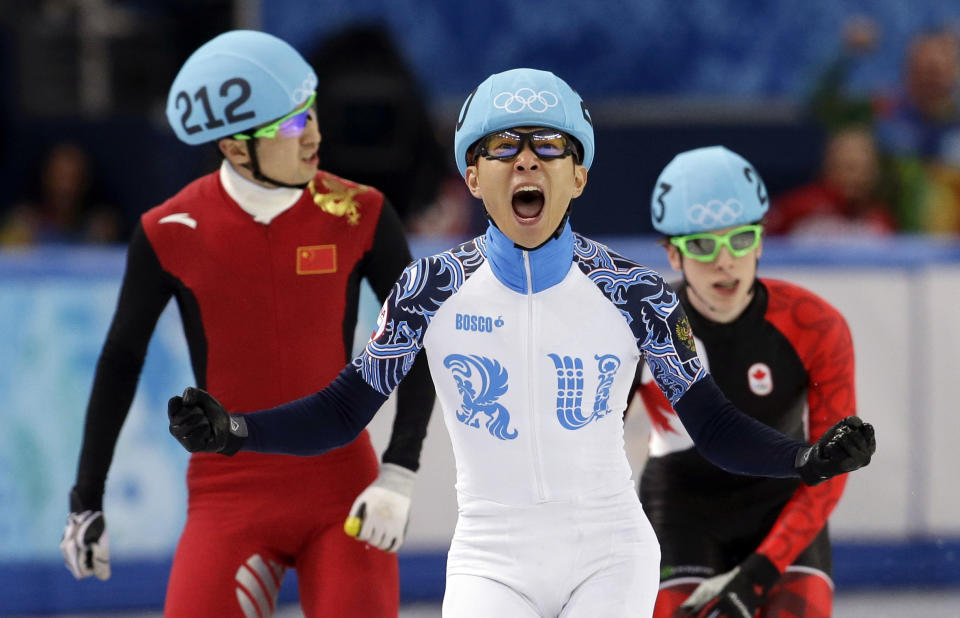 Victor An, center, of Russia, reacts as he crosses the finish line ahead of Wu Dajing, left, of China, and Charle Cournoyer of Canada in the men's 500m short track speedskating final at the Iceberg Skating Palace during the 2014 Winter Olympics, Friday, Feb. 21, 2014, in Sochi, Russia. (AP Photo/Darron Cummings, File)