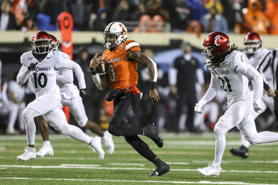 FILE - Oklahoma State running back Ollie Gordon II (0) runs past Cincinnati safety Bryon Threats (10) and defensive back Kalen Carroll (21) during the second half of an NCAA college football game Oct. 28, 2023, in Stillwater, Okla. Gordon II is The Associated Press Big 12 offensive player of the year. (AP Photo/Mitch Alcala, File)