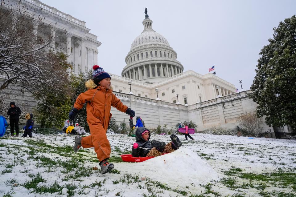 Children race each other down the sledding hill at the U.S. Capitol, following a snowstorm that closed schools on January 16, 2024.