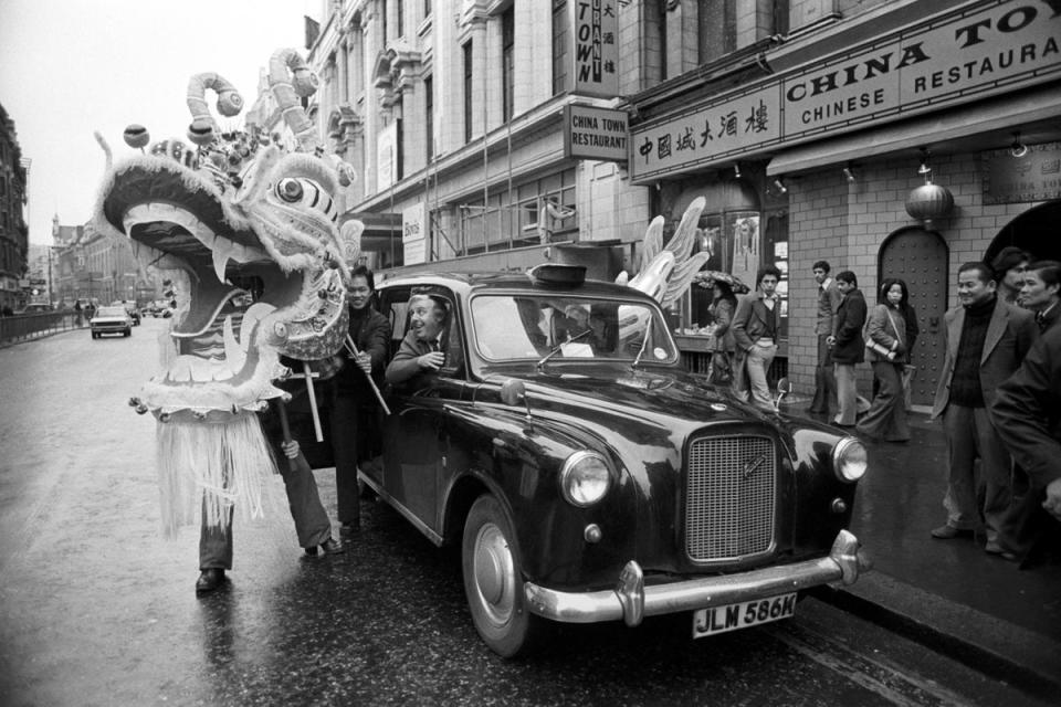Taxi driver Harry Meldrum of Ilford drops off the star attraction in the Chinese Dragon Dance to be held in Trafalgar Square to mark the Chinese New Year in 1977 (PA)
